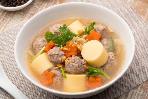 Close up Clear glass noodle soup with Minced Pork,Vegetables and egg tofu (Gaeng Jued Woon Sen).