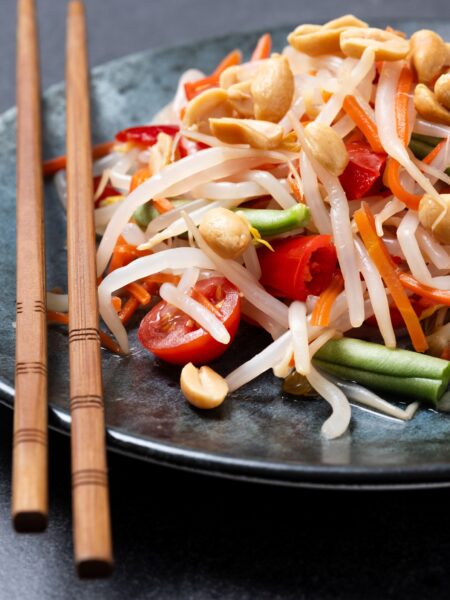 Green papaya salad som tam thai on black slate background