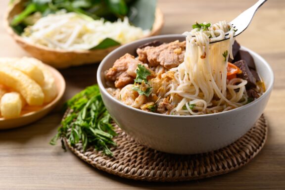 Northern Thai food (Kanom Jeen Nam Ngeaw), Spicy rice noodles soup with pork and pork blood eating with fresh vegetables.