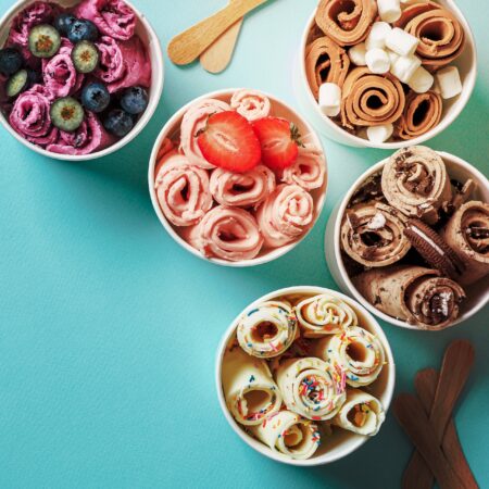 Rolled ice creams in cone cups on blue background