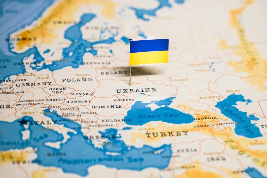 A small Ukrainian flag pin placed on Ukraine on a world map.