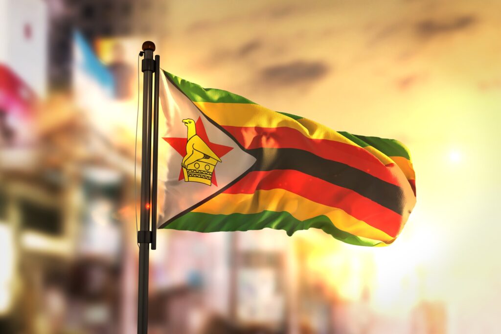 The flag of Zimbabwe waving with a blurred background.