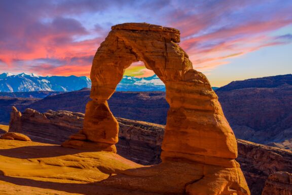 Delicate Arch during sunset with vibrant pink and blue skies in Arches National Park, Utah.