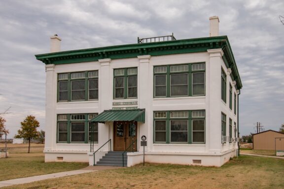 A two-story historical building with a green awning over the main entrance and a sign that reads "KNOX COUNTY, COURTHOUSE ANNEX" under a cloudy sky.