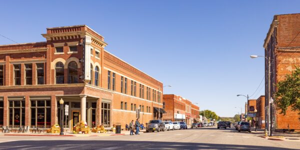 People are about to cross a mostly empty street in Osage County’s town of Pawhuska.