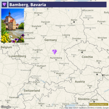 Map of central Europe highlighting Germany with a focus on the location of Bamberg, Bavaria, indicated by a purple diamond. An inset image shows a picturesque building in Bamberg beside a river, with flowers in the foreground.