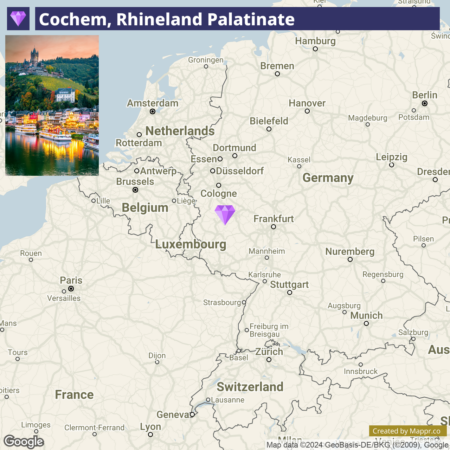 A map highlighting Cochem in Rhineland Palatinate, Germany, with a small image of a castle on a hill above a town with brightly lit buildings reflected in water at night on the left side and a location marker over Cochem on the map.