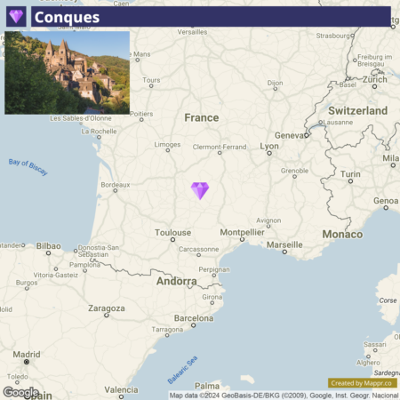 A Google map screenshot showing a highlighted location marker for Conques in the south of France, with an inset photograph of a historical stone village nestled in greenery. Surrounding areas on the map include major cities like Bordeaux, Toulouse, and Marseille, as well as the Bay of Biscay to the northwest and the borders of Spain, Andorra, and Italy.