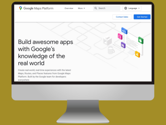 Webpage on a computer monitor displaying Google Maps Platform with texts "Build awesome apps with Google's knowledge of the real world" and icons related to web development, like HTML and JavaScript.