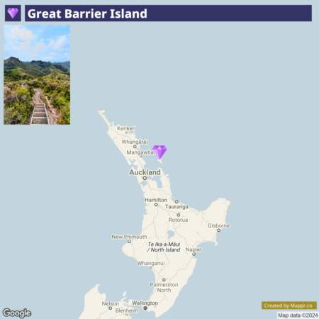 An image showing a combination of a map and a photograph. The map highlights the location of Great Barrier Island off the northeastern coast of New Zealand's North Island, with a purple pin marking the island's position. Above the map is a photograph of a scenic view from the island, featuring a wooden walkway leading through lush greenery and hills under a clear sky. Map attribution included: Created by Mapp.nz, with map data ©2024 Google.