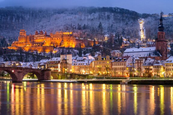 Illuminated Castle Overlooking Snowy Town at Dusk Heidelberg's romantic allure