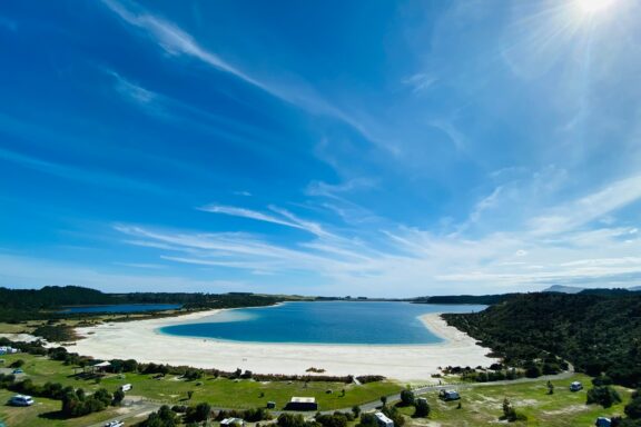 Kai's Iwi Lakes' tranquil waters in Northland's sandy embrace