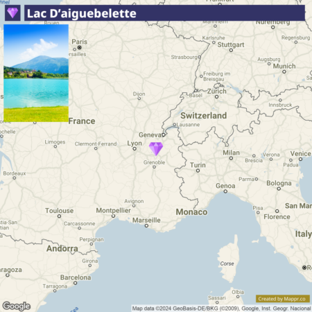 A map of part of Western Europe highlighting the location of Lac D'aiguebelette in France, with a small thumbnail photo of the lake in the lower-left corner showing clear turquoise water and a mountain in the background.