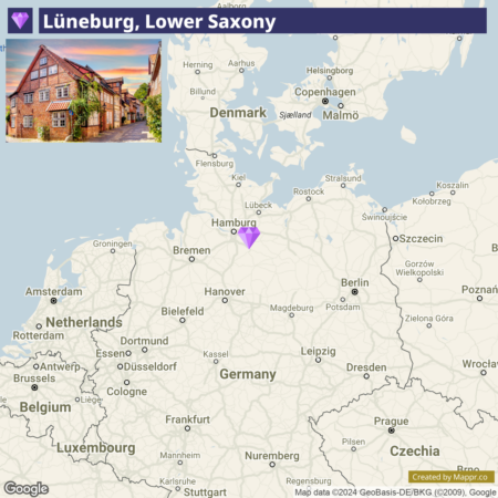 Alt text: A map highlighting Lüneburg in Lower Saxony, Germany, marked with a purple triangle, with an inset photo in the lower left corner depicting a traditional half-timbered house at sunset.