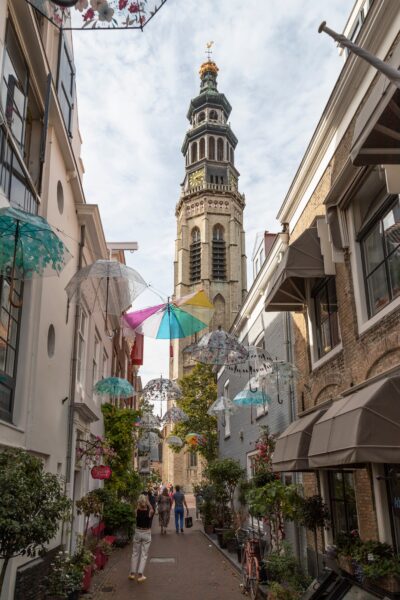 A bustling street in Middelburg leading to the Tall John Abbey Tower