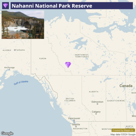 A map showing Nahanni National Park Reserve located in the Northwest Territories of Canada, highlighted with a purple diamond-shaped marker. In the inset photo in the upper left corner, a scenic view of Virginia Falls in the park with water cascading down a cliff surrounded by autumn-colored trees.