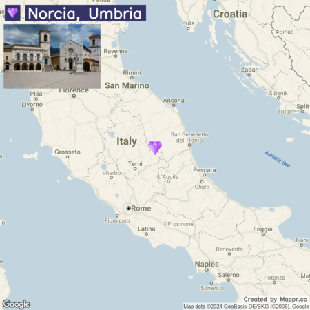 A map highlighting the location of Norcia in Umbria, Italy, with a photo inset showing a square with historical buildings in Norcia.