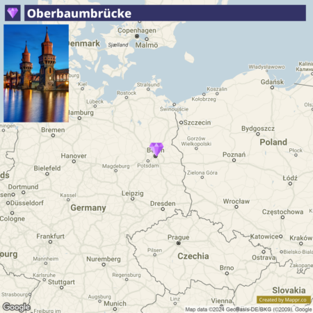 A map displaying the Oberbaumbrücke location in Germany with neighboring countries and major cities. The area around Berlin is highlighted, and a picture of the Oberbaum Bridge at night with illuminated towers is inset in the upper left corner.