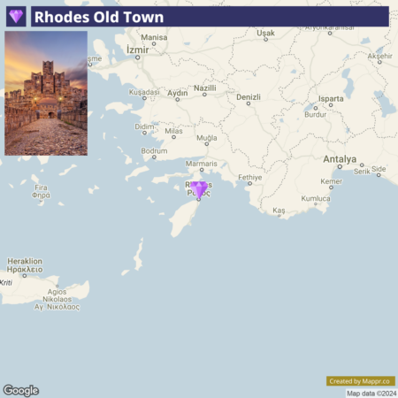 A map highlighting Rhodes Old Town with a superimposed photograph of the historical site at dusk, showing stone walls and a medieval castle against a purple sky. Surrounding areas in Turkey and Greece are labeled with city names, and the map includes part of the Mediterranean Sea.