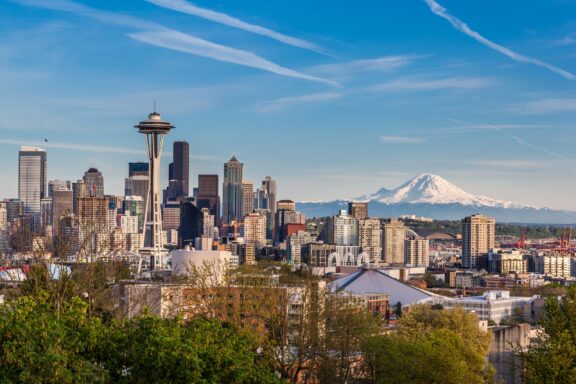 Seattle skyline with the Space Needle and Mount Rainier in the background on a clear day.