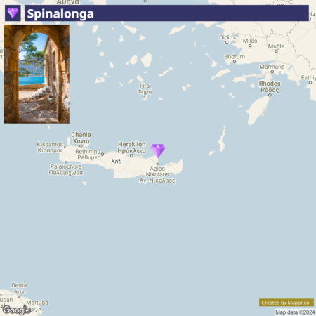 A screenshot of a map highlighting the location of Spinalonga near Crete, Greece, with a partial view of arches from a stone structure in the foreground.