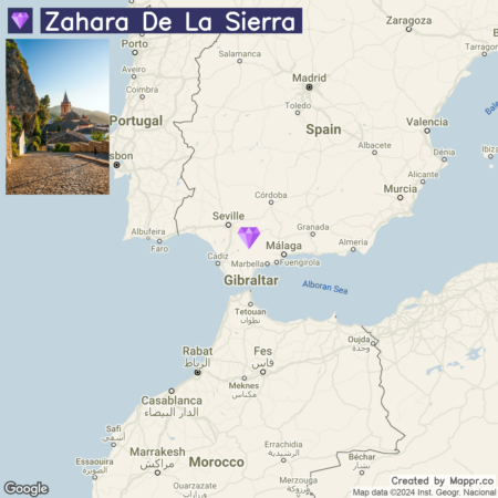 A map graphic featuring a location marker for Zahara de la Sierra in Spain with an inset photograph of a cobblestone street leading towards a church in the town.