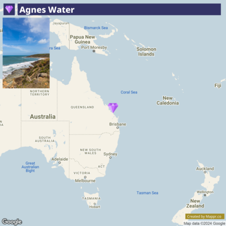 A map of the eastern region of Australia with a highlighted location marker indicating Agnes Water in Queensland. The map also shows parts of Papua New Guinea, Solomon Islands, and New Caledonia, with a small inset picture of a coastal landscape in the upper left corner.