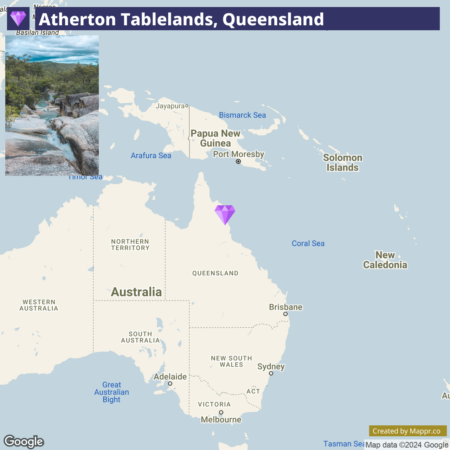 A map highlighting the Atherton Tablelands in Queensland, Australia, with a diamond-shaped marker. Surrounding regions and bodies of water, including Papua New Guinea, the Solomon Islands, the Coral Sea, and various Australian states, are also depicted.