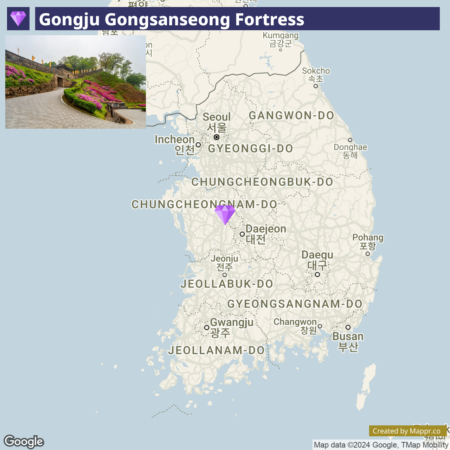 An image of a map highlighting the location of Gongju Gongsanseong Fortress in South Korea, with a pinned marker over the northwestern part of South Chungcheong province near Daejeon. The upper left corner displays a small image of a pathway within the fortress, adorned with colorful flowers. There's a Google logo and map attribution on the bottom.