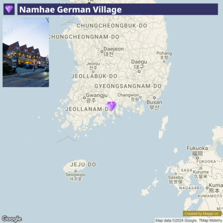 A map highlighting Namhae German Village's location with a marker, showing nearby South Korean cities such as Busan, Jeonju, and Daegu, and parts of Japan like Fukuoka and Nagasaki to the east. The map also includes a small inset photo in the upper left corner, showing a nighttime view of the village with buildings illuminated and people walking around.